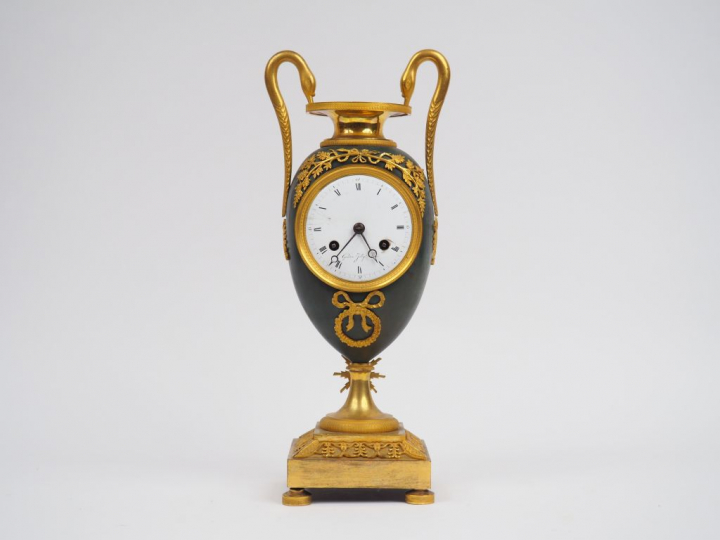 	Pendule Empire en bronze patiné et doré, à décor de col de cygne. Cad