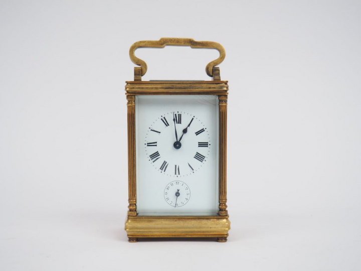 Pendulette de voyage en bronze et cristal. Dim. : 12,5 x 7,5 x 6 cm.
