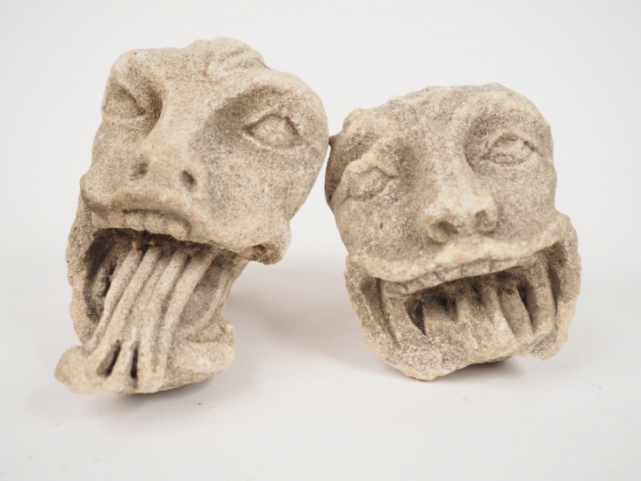 	Deux têtes de monstres grimaçants en pierre sculptée, on joint un élé