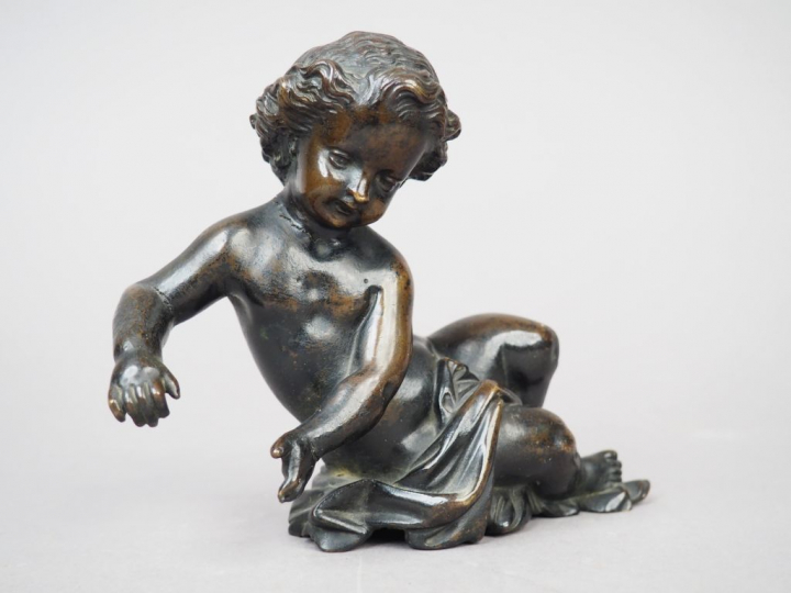 Enfant allongé en bronze patiné. XIXème siècle. H. 12 cm (fissure au c