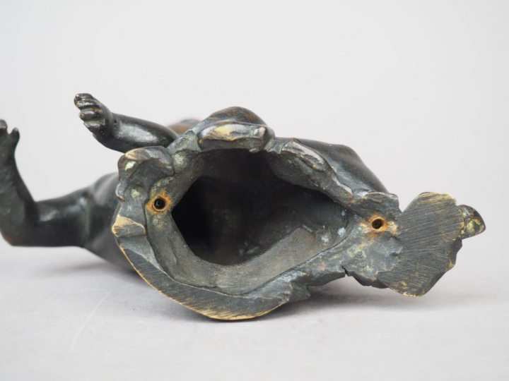Enfant allongé en bronze patiné. XIXème siècle. H. 12 cm (fissure au c