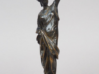 Vente aux enchères Femme drapée à l’antique tenant une lampe à huile en bronze patiné. Dé