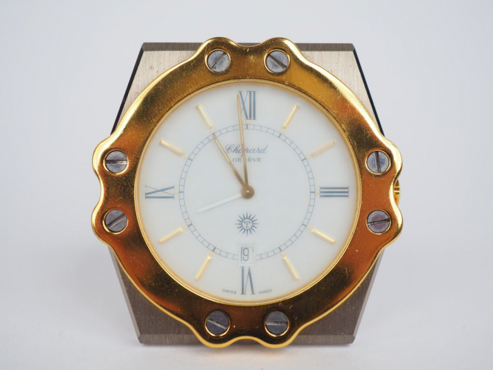 CHOPARD.  Petite pendulette de table en acier.  Cadran blanc à chiffre