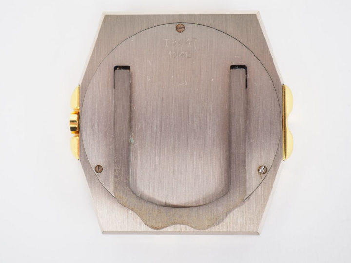 CHOPARD.  Petite pendulette de table en acier.  Cadran blanc à chiffre