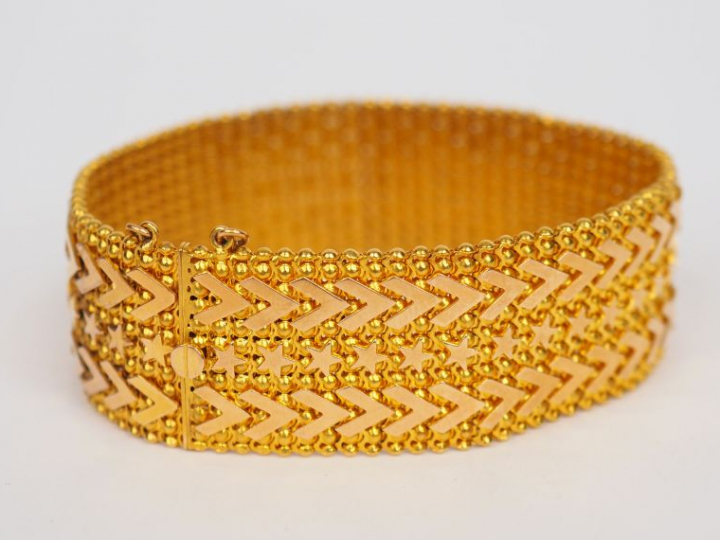 Bracelet manchette en or jaune, maille plate à décor d’étoiles et de m