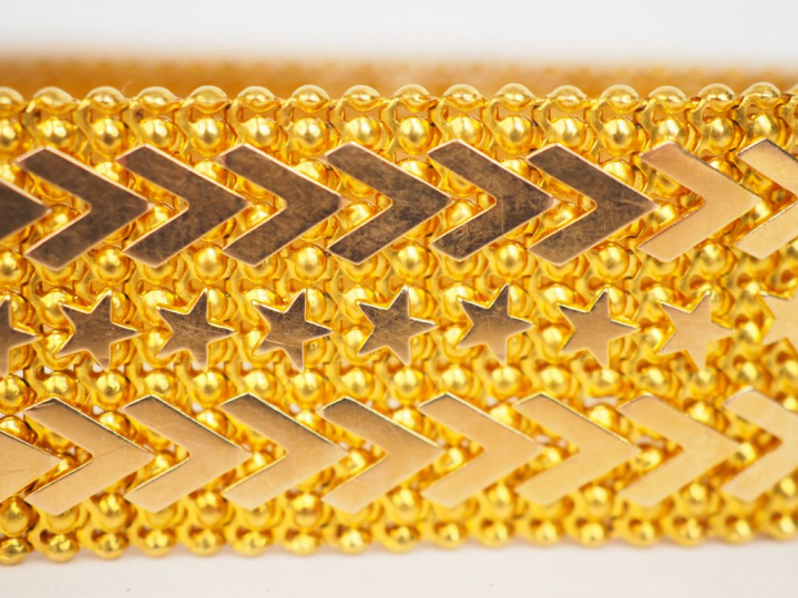 Bracelet manchette en or jaune, maille plate à décor d’étoiles et de m