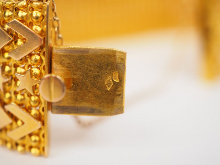 Bracelet manchette en or jaune, maille plate à décor d’étoiles et de m