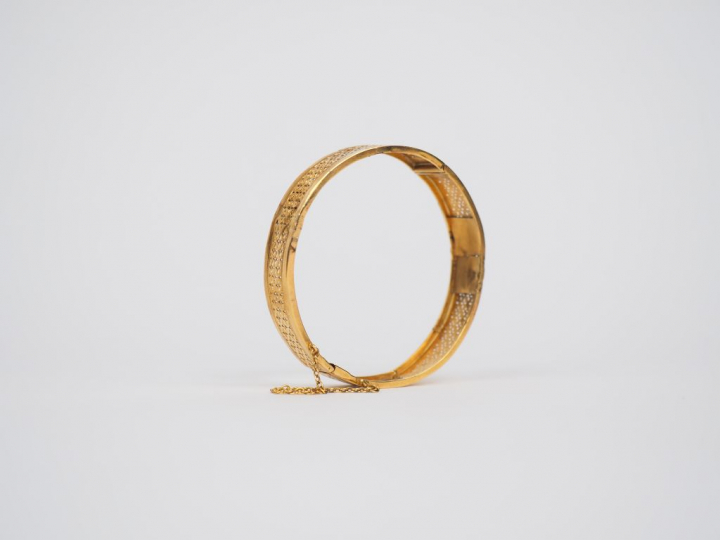 Bracelet rigide en or jaune, à décor ajouré.  Poids. 11,89 g (petits a