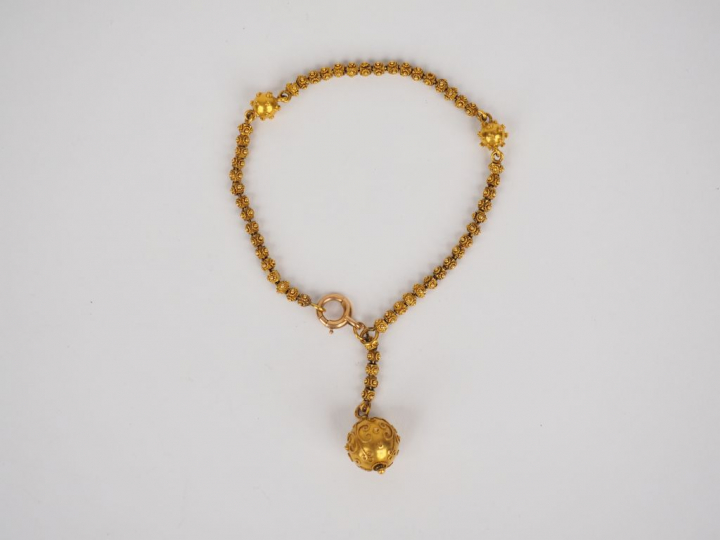 	Bracelet en or jaune, à décor d’une pendeloque en forme de boule.  Po