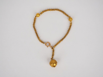 Vente aux enchères 	Bracelet en or jaune, à décor d’une pendeloque en forme de boule.  Po