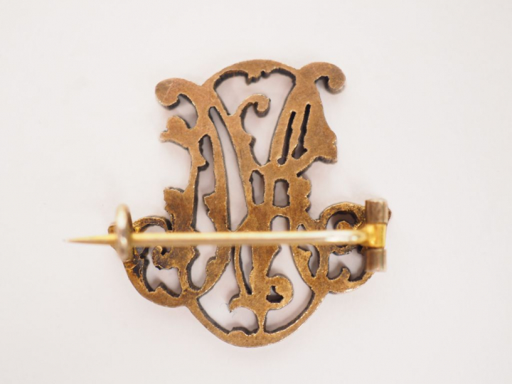 	Broche en or jaune, à décor de monogramme. 3 x 2,5 cm  Poids. 5.15 g