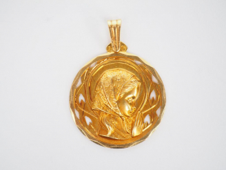 Vente aux enchères Médaille religieuse en or jaune, figurant une jeune fille en prière.  