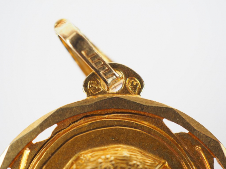 Médaille religieuse en or jaune, figurant une jeune fille en prière.  