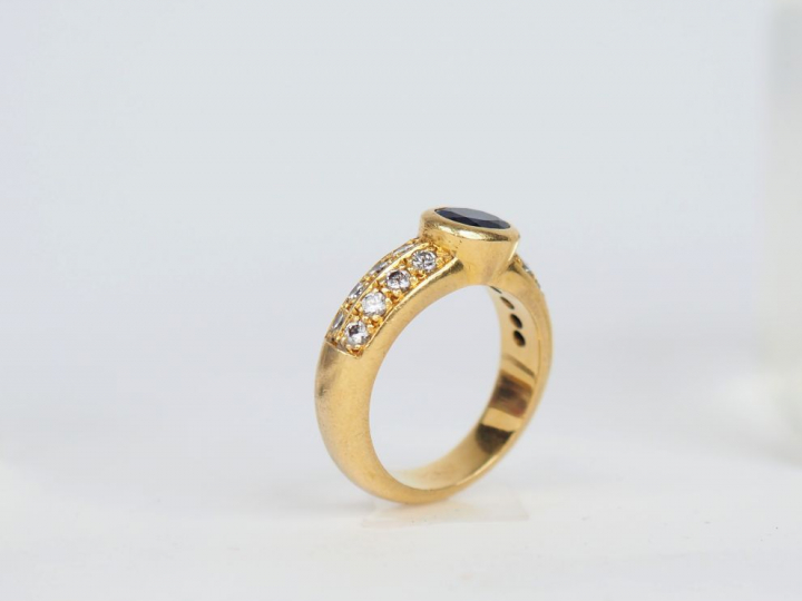 Bague en or jaune sertie en son centre d'un saphir épaulé de part et d