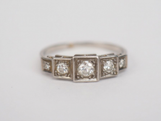 Vente aux enchères Bague de style Art déco en platine, sertie de quatre petits diamants. 