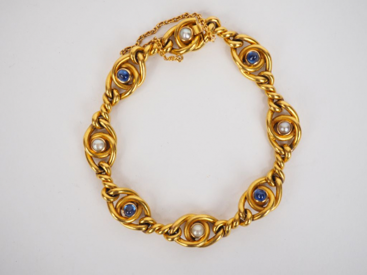 Bracelet souple en or jaune, à décor de perles et de pierres bleues en
