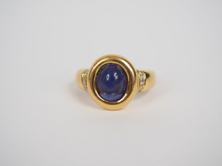 Bague en or jaune orné en son centre d'une pierre violette en cabochon