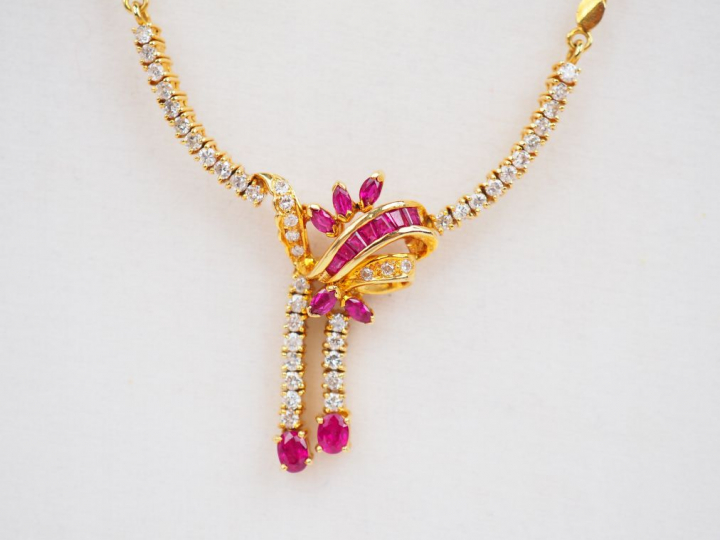 Collier en or jaune, orné en son centre de petits diamants, rubis et r