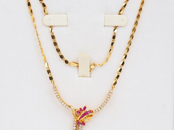 Collier en or jaune, orné en son centre de petits diamants, rubis et r