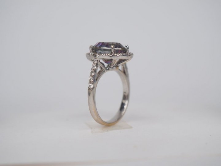 Bague en or blanc sertie en son centre d'une pierre entourée de petits