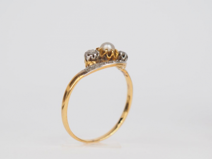 Bague en or jaune, ornée en son centre d'une perle entourée de petits 