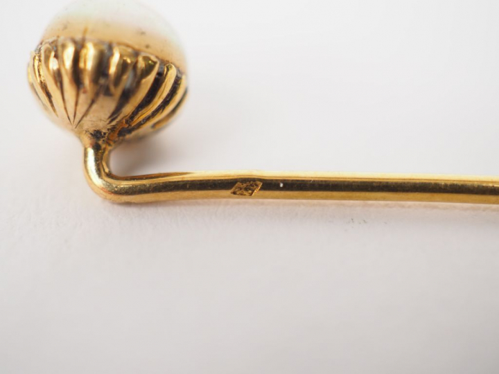 Ensemble comprenant :  - deux épingles à cravate en or jaune et perle.