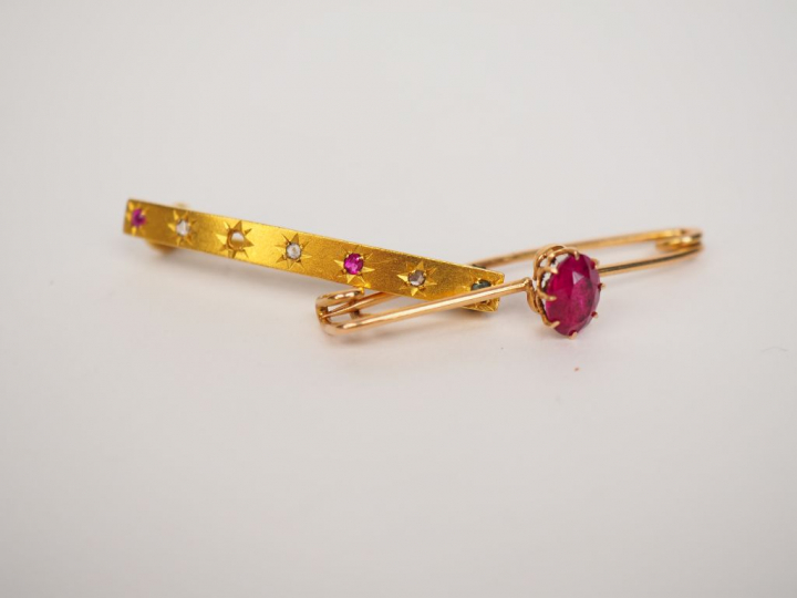 Broche en or jaune, ornée d’une pierre de couleur. Poids tel. 1.65 g	 