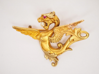 Vente aux enchères Broche en or jaune en forme de chimère tenant dans sa gueule une perle