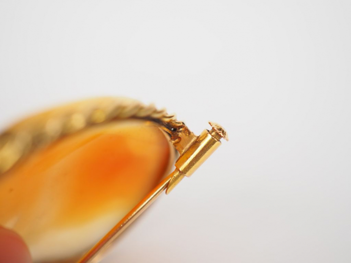 	Broche ornée d’un camée coquille, à décor de profil de femme à l’anti