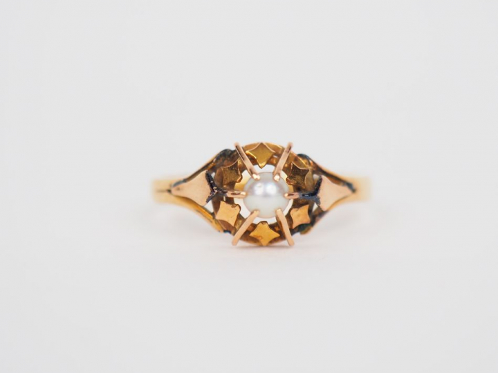 Bague en or jaune, ornée en son centre d'une perle en cabochon. TDD. 5