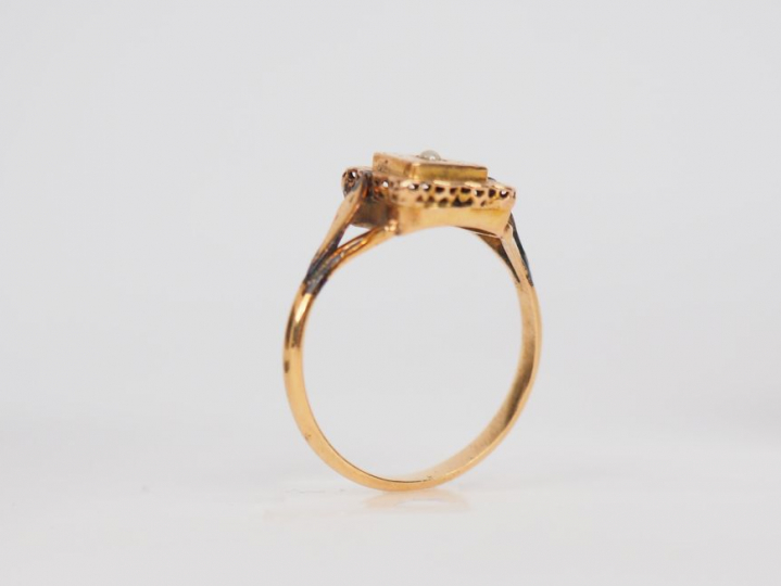 Bague carrée en or jaune, ornée en son centre d'une petite perle. TDD.