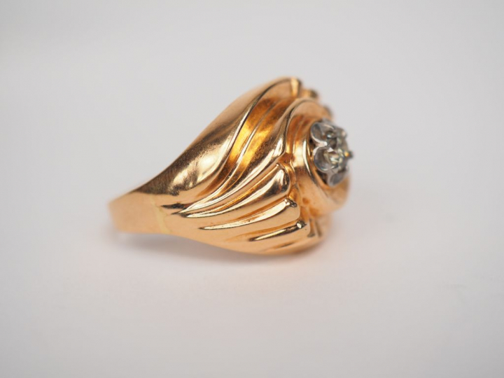 Bague en or jaune en forme de tourbillon, sertie en son centre d'un pe