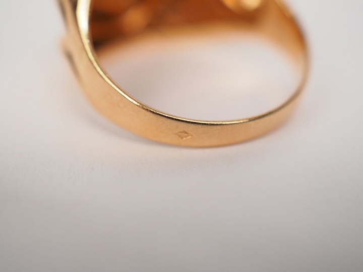 Bague en or jaune en forme de tourbillon, sertie en son centre d'un pe