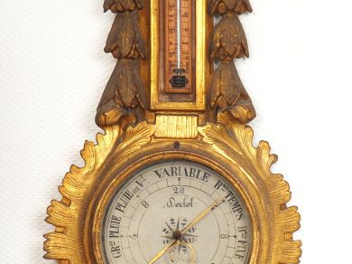 Baromètre thermomètre de style Louis XVI en bois sculpté et doré. H. :