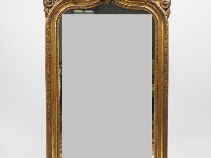 Glace Napoléon III en bois et stuc doré, à décor de tête de personnage