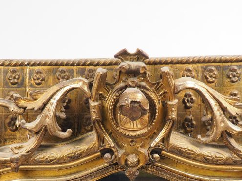 Glace Napoléon III en bois et stuc doré, à décor de tête de personnage