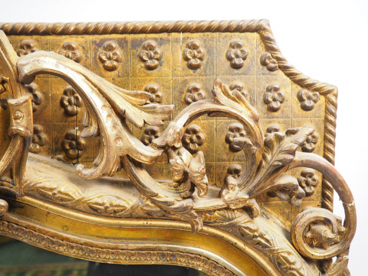 Glace Napoléon III en bois et stuc doré, à décor de tête de personnage