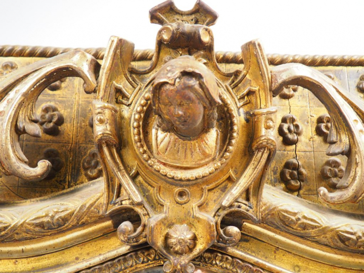 Glace Napoléon III en bois et stuc doré, à décor de tête de personnage