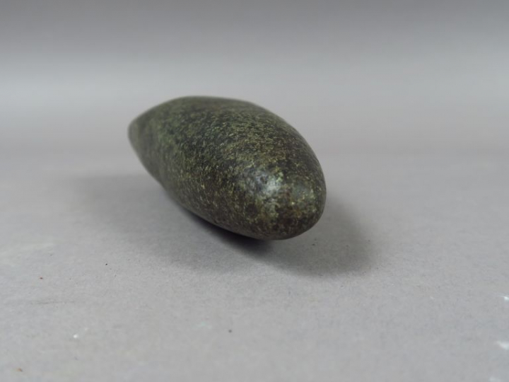 Hache polie en pierre d’un vert sombre. L. : 17,5 cm.