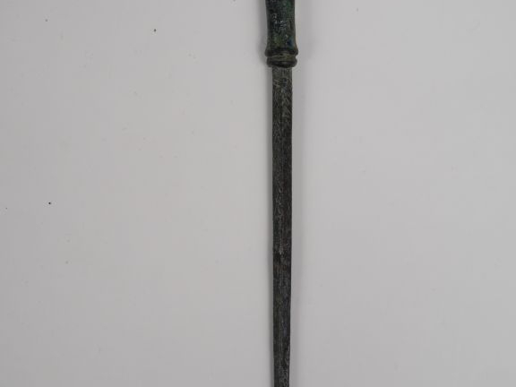 Grande épingle en bronze dont la tête est décorée d’un protomé animal.