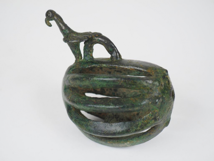 Grelot ovoïde surmonté d’un oiseau et d’un anneau de suspension. Luris