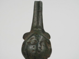 Vente aux enchères Fragment d’une anse en bronze décorée d’une tête. H. : 9 cm.