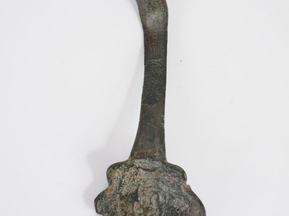 Anse en bronze avec un visage en médaillon. Epoque romaine. L. : 16 cm