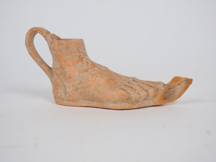 Lampe romaine en terre cuite en forme de pied portant une sandale. Bec