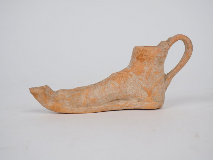 Lampe romaine en terre cuite en forme de pied portant une sandale. Bec