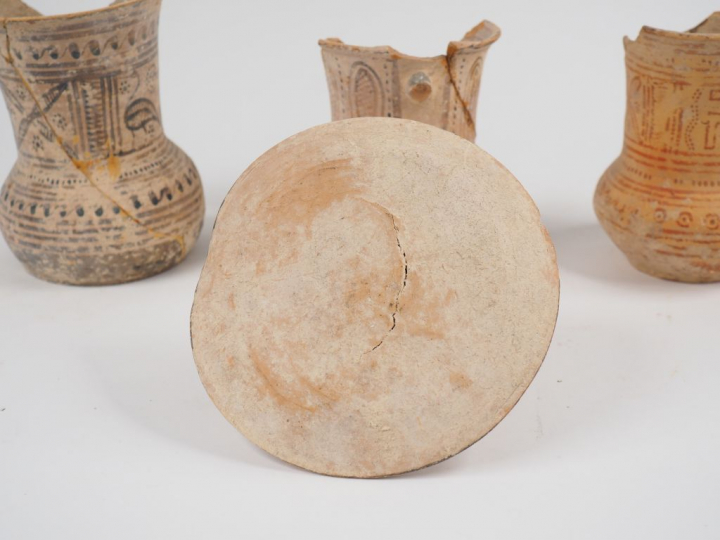 Trois pichets à haut col (Ht. de 14.5 à 16.5 cm) et un couvercle (7.5 