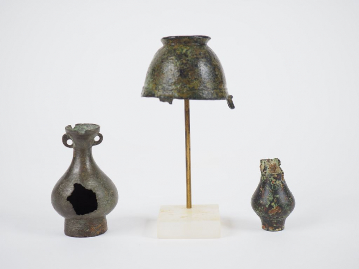 Trois vases votifs en bronze. Accidents.  H. : 7 cm, 4.5 cm, 4 cm.