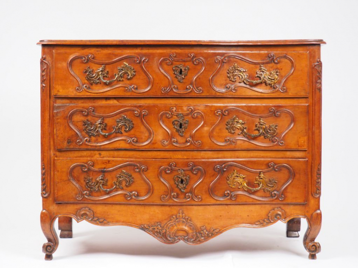 Commode Louis XV en noyer mouluré et sculpté, ouvrant à trois tiroirs,