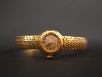 Vente aux enchères OMEGA. Montre de dame en or jaune, boitier et bracelet en or jaune.  P