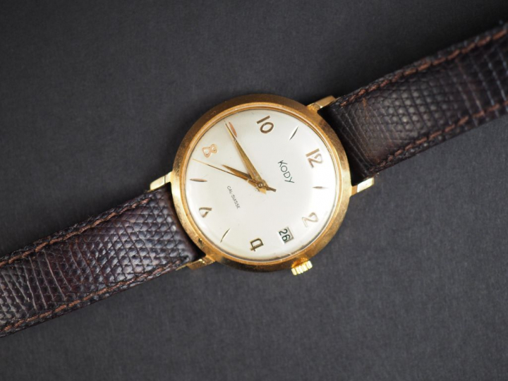 KODY. Montre d'homme, boitier en or jaune.  Bracelet cuir.  Guichet da